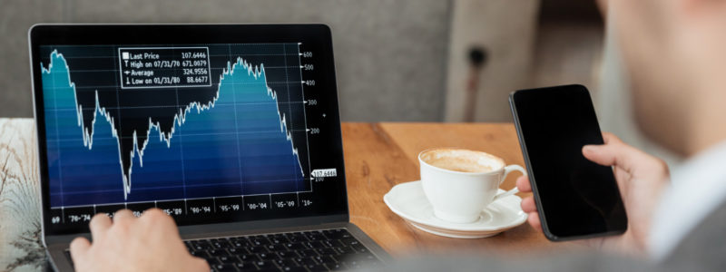 preços de ações variando enquanto homem os analisa através de um gráfico
