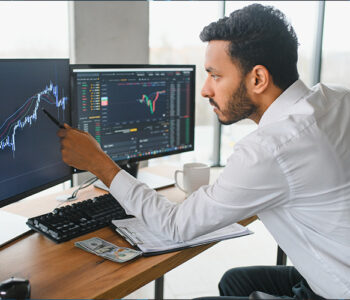 Retrato de um investidor bem-sucedido analisando gráficos da bolsa de valores na tela do computador.